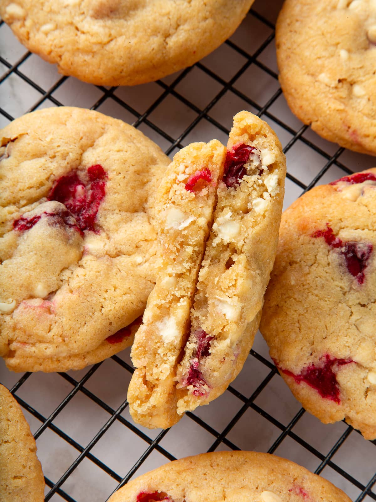 Cookie showing its chewy inside filled with melted white chocolate and cranberries.