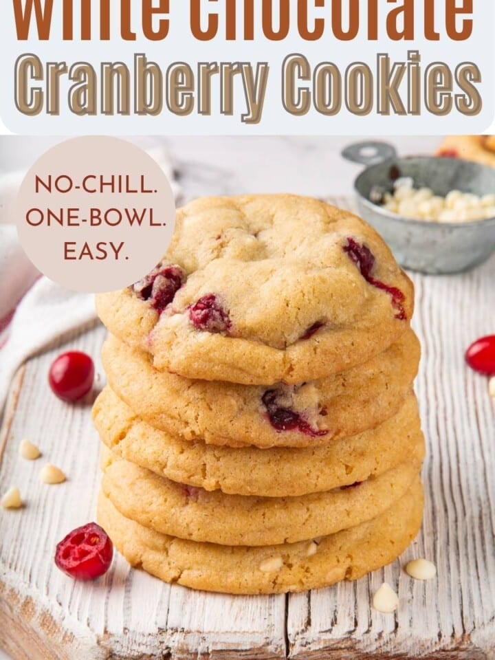 Stack of chewy white chocolate cranberry cookies showing soft, buttery centers and colorful cranberry pieces.