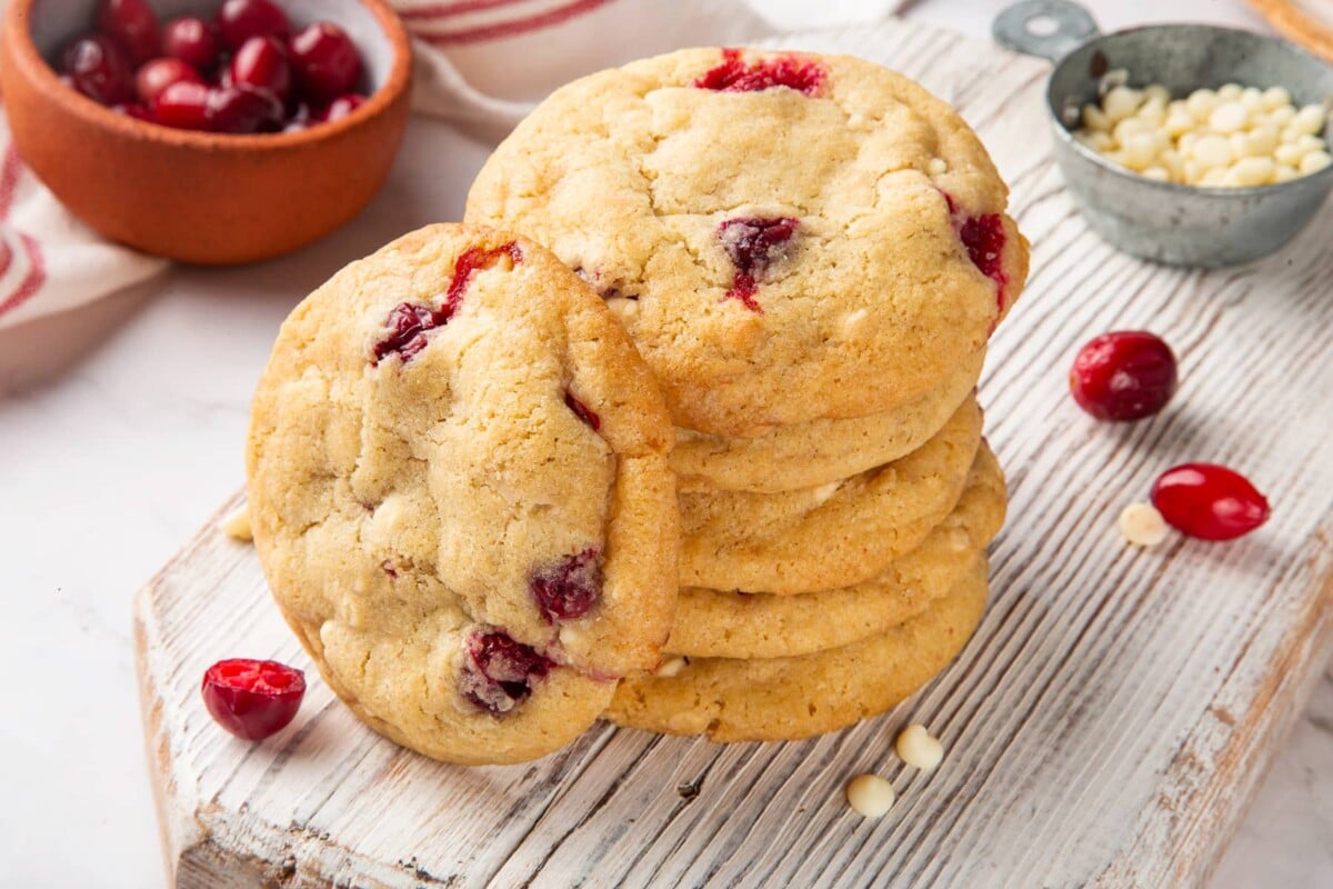Several whole white chocolate cranberry cookies baked until golden with bits of cranberry showing through.