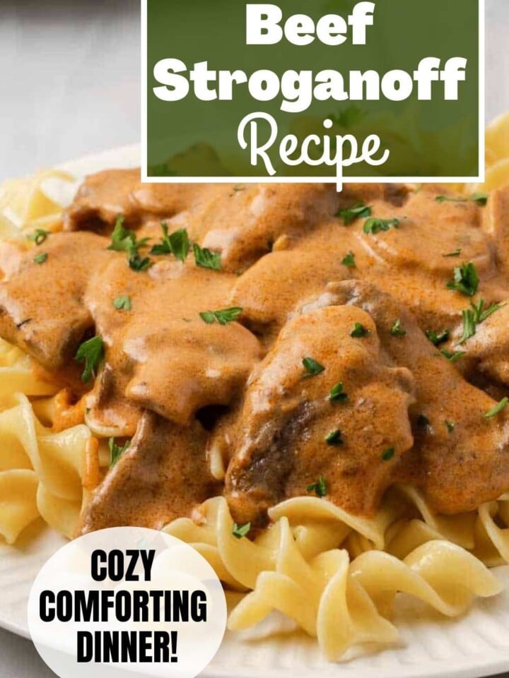 Beef stroganoff in a creamy mushroom sauce garnished with parsley on a plate of noodles.