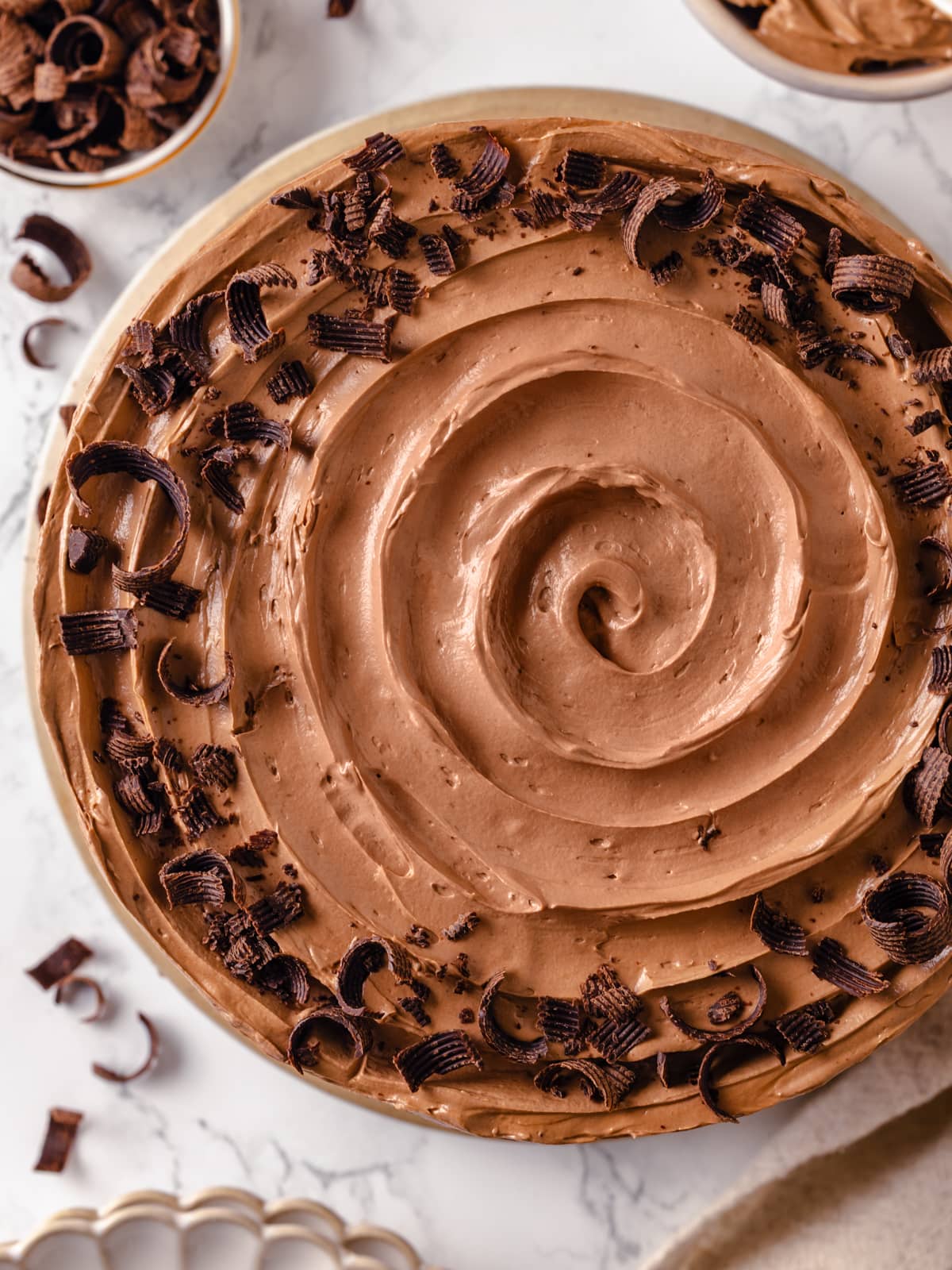 A swirl of chocolate Swiss meringue buttercream topped with tiny chocolate shavings.