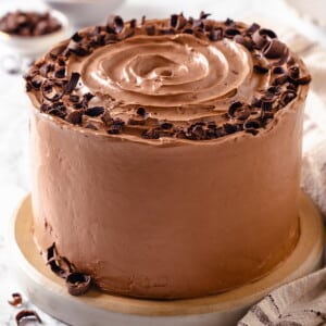 A full round cake completely coated in chocolate Swiss meringue buttercream.
