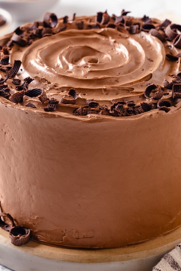 A full round cake completely coated in chocolate Swiss meringue buttercream.