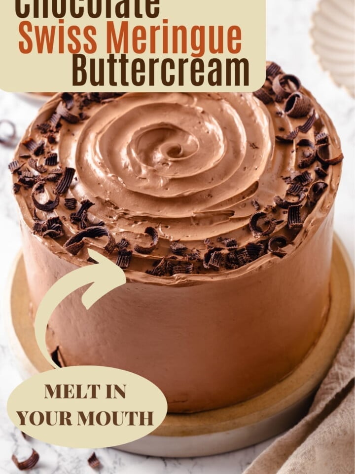 Piped chocolate Swiss meringue buttercream forming pretty swirls on a fresh cake.