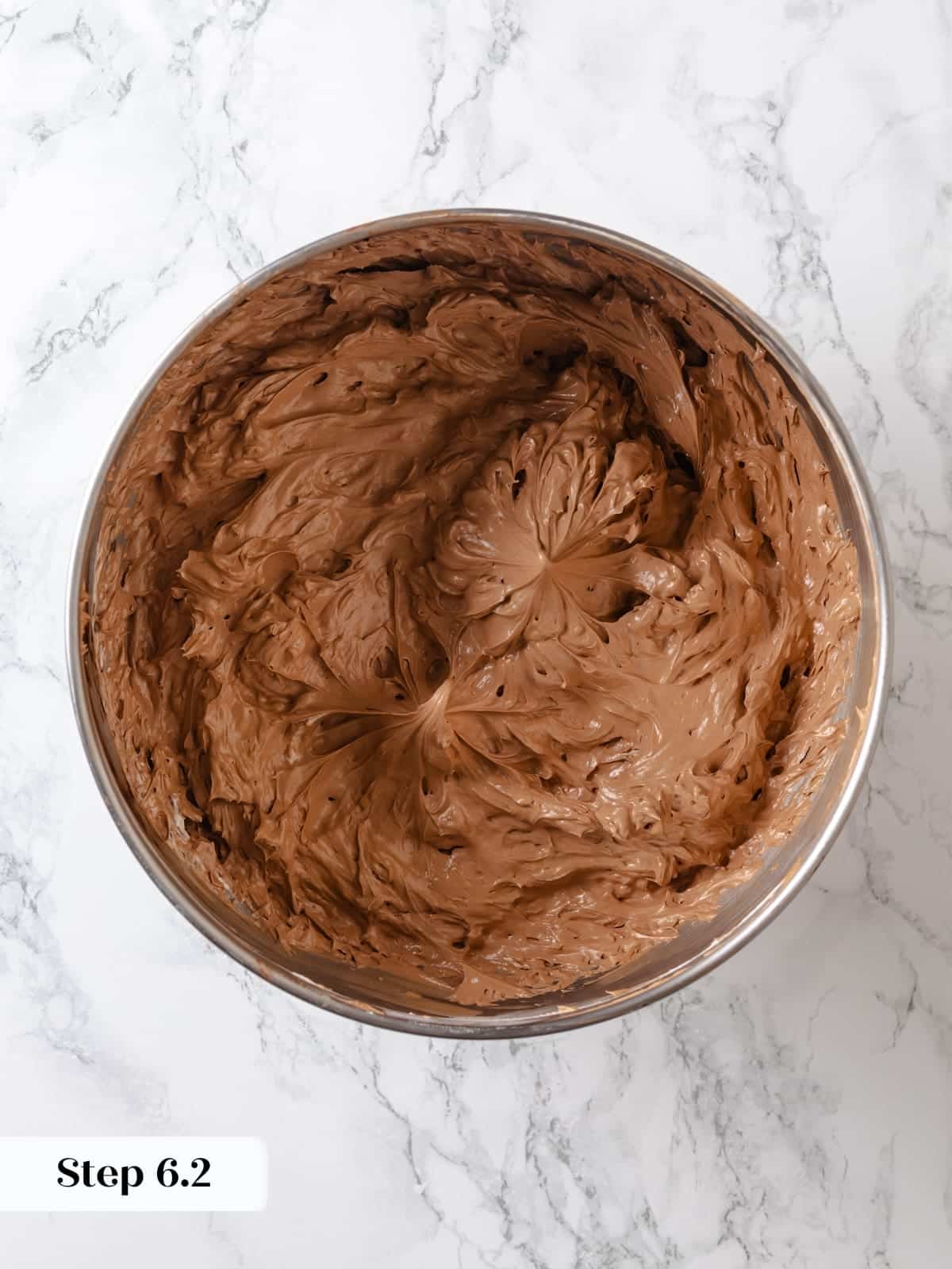 Fully mixed chocolate Swiss meringue buttercream sitting in a bowl ready for spreading.