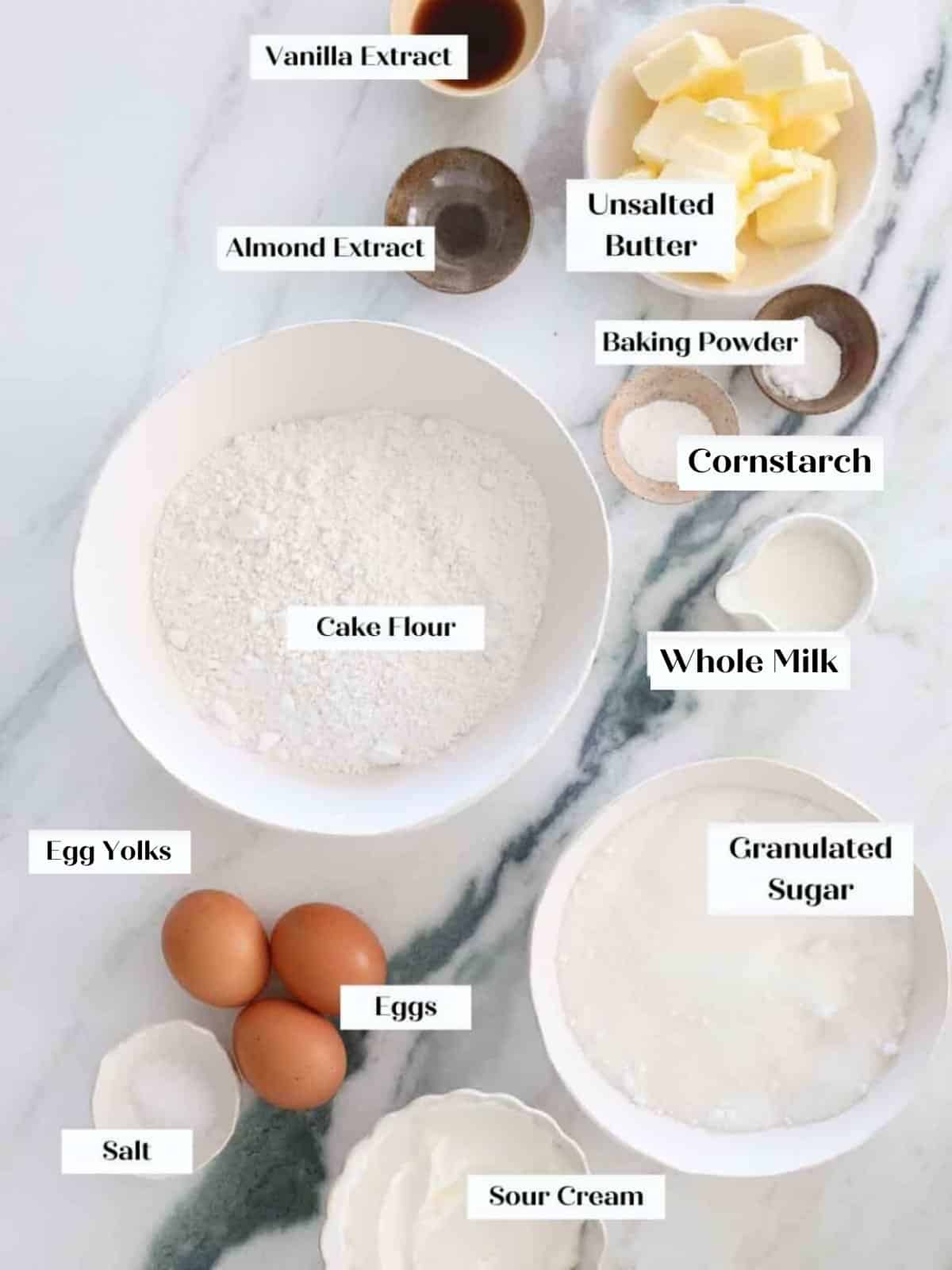Measured baking ingredients displayed together for preparing classic yellow cake recipe.