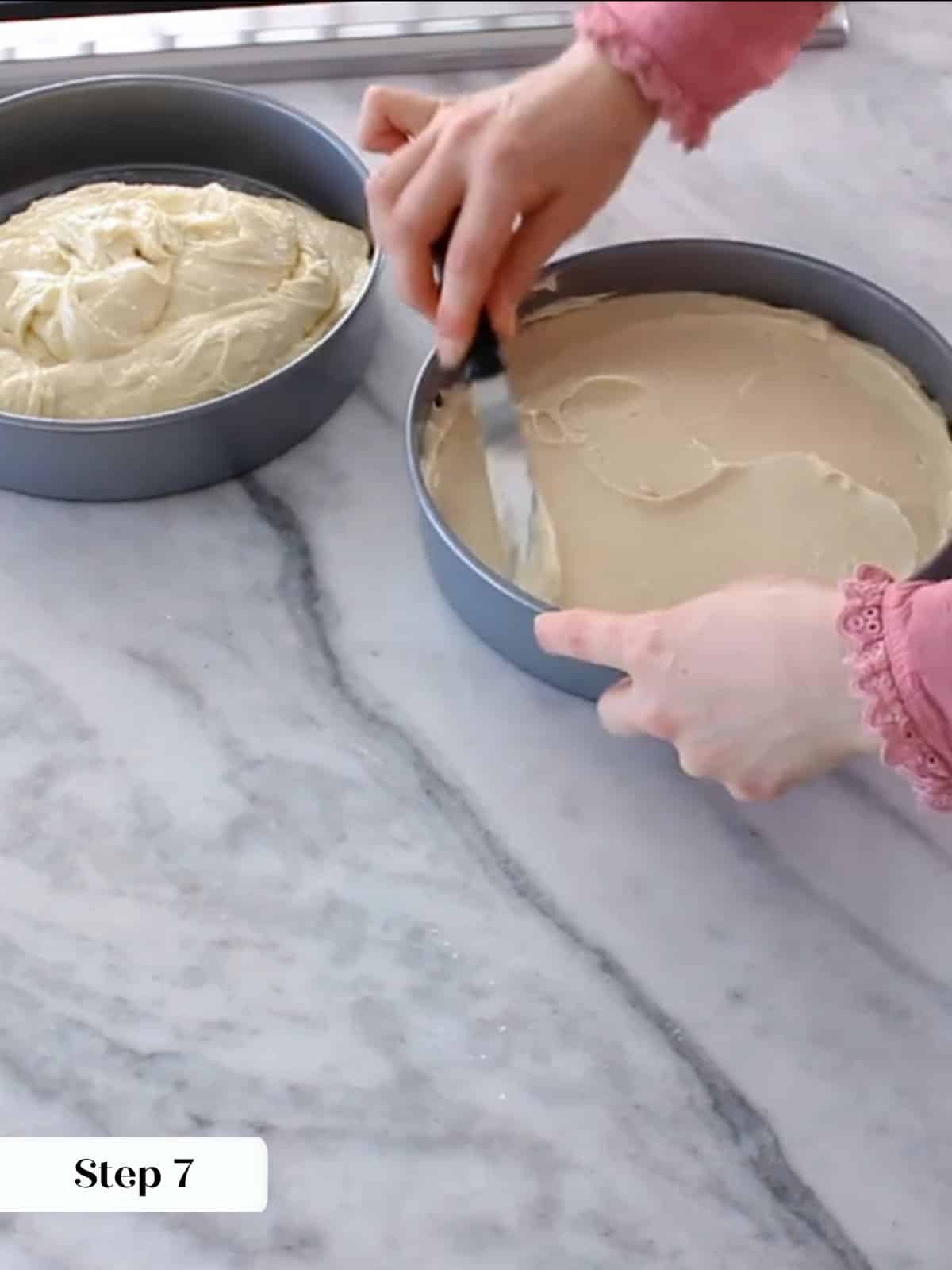 Yellow cake batter divided evenly between prepared pans before baking in oven.