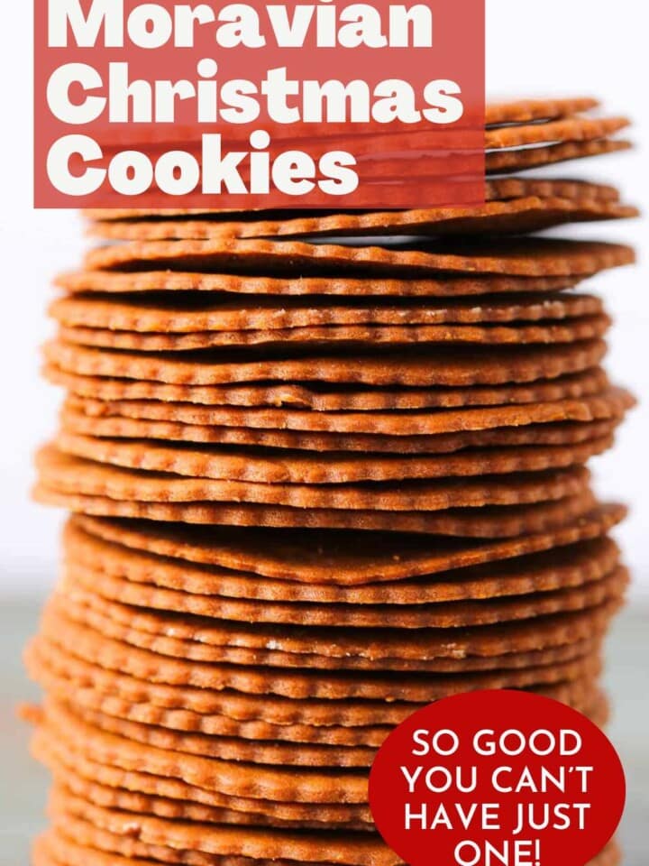 Stack of thin, round, golden brown moravian cookies with scalloped edges.