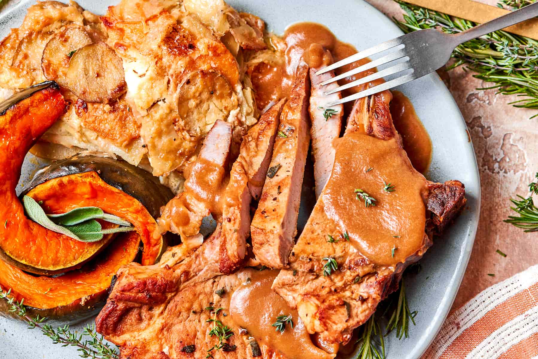 Pan-seared pork chop paired with warm applesauce sauce for dinner.