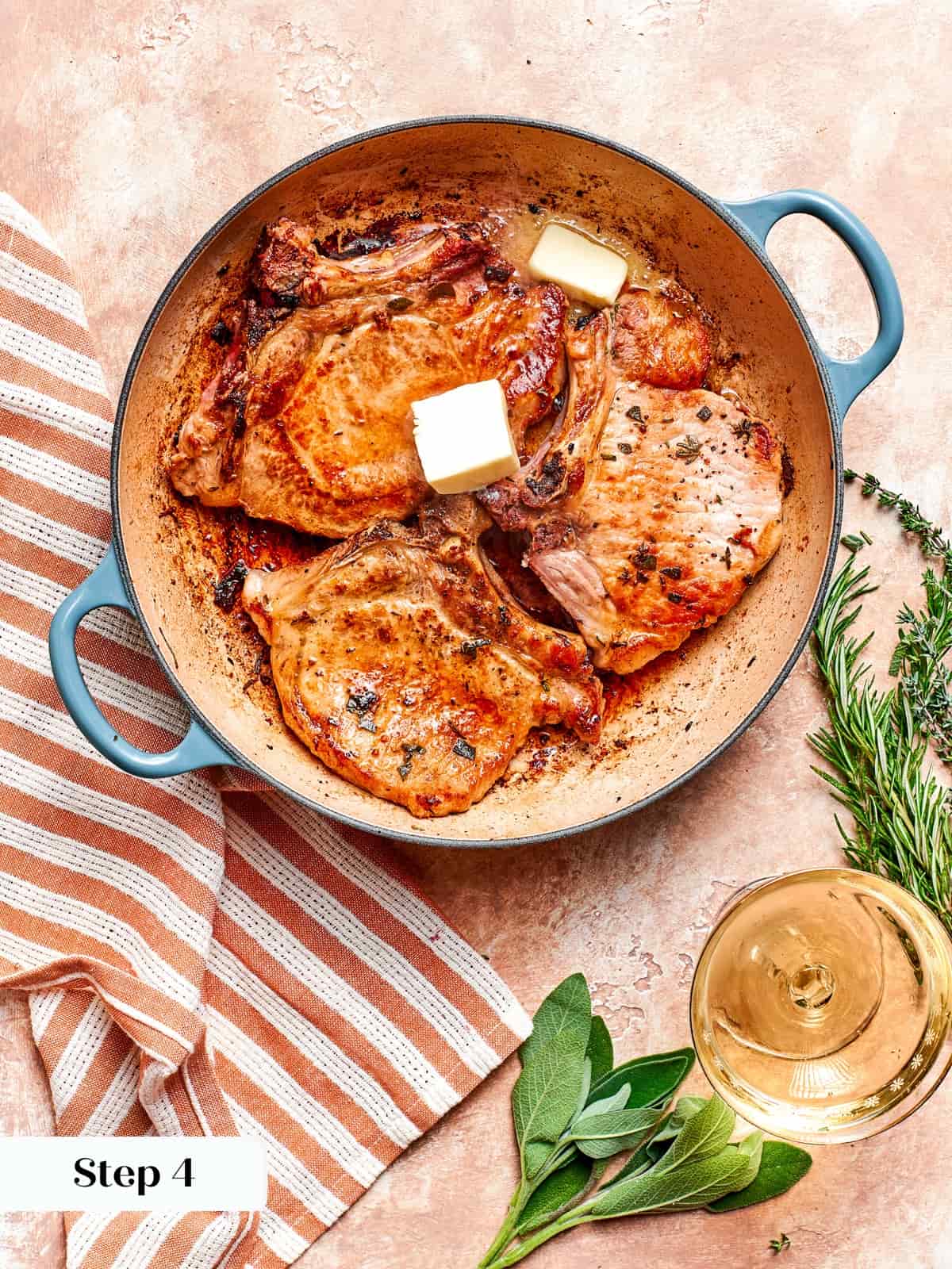 Butter added to pan to baste pork chops before resting.