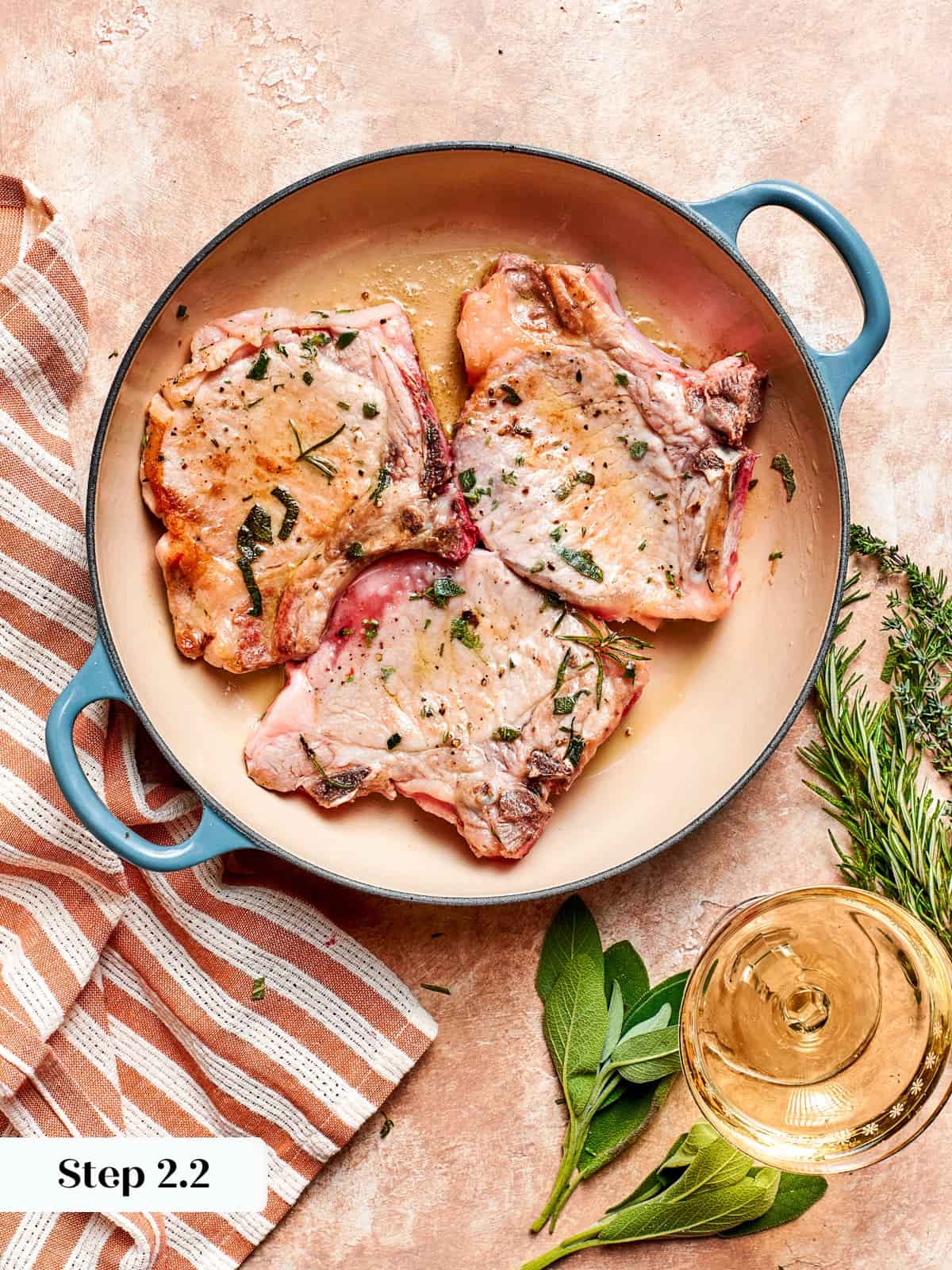 Pork chops flipped in hot skillet as second side browns evenly.