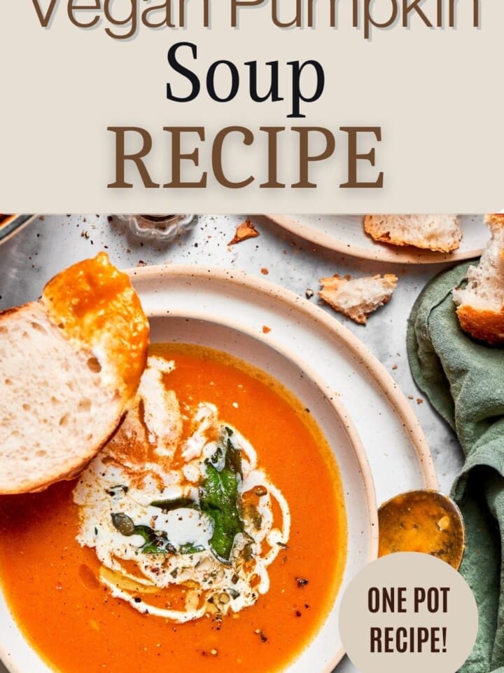 Smooth dairy free pumpkin soup in a cozy fall setting with a spoon and napkin.