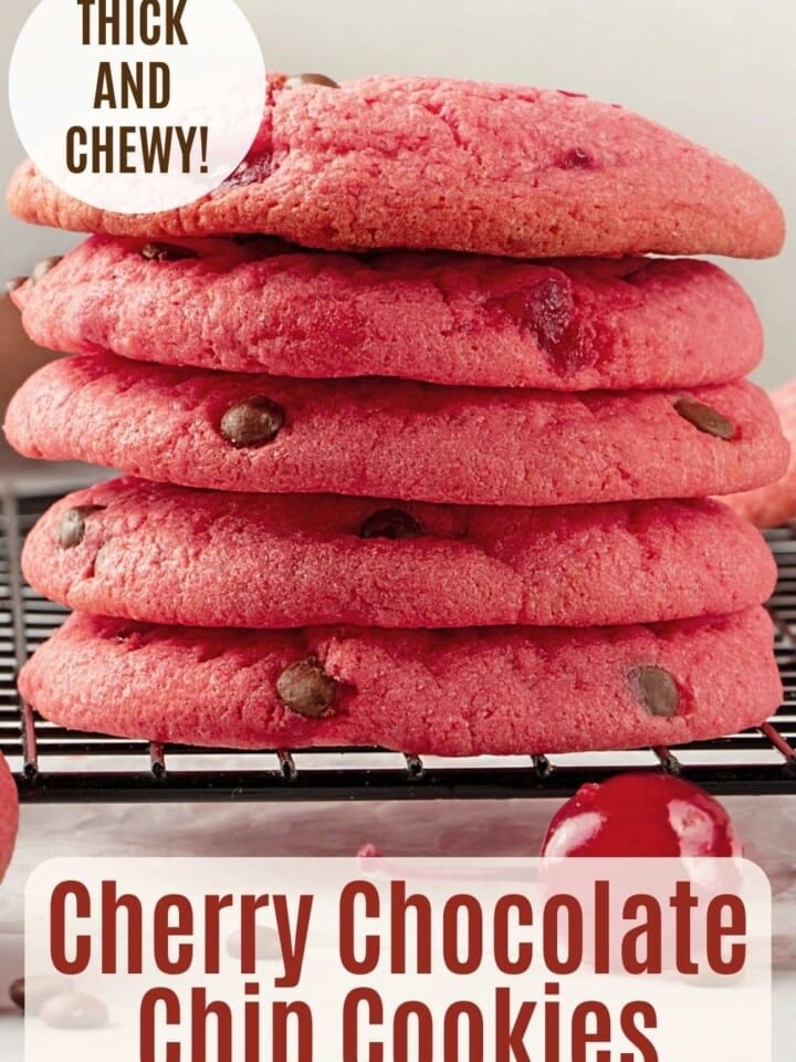 Stack of thick and pink chewy cookies with mini chocolate chips and chunks of maraschino cherries.