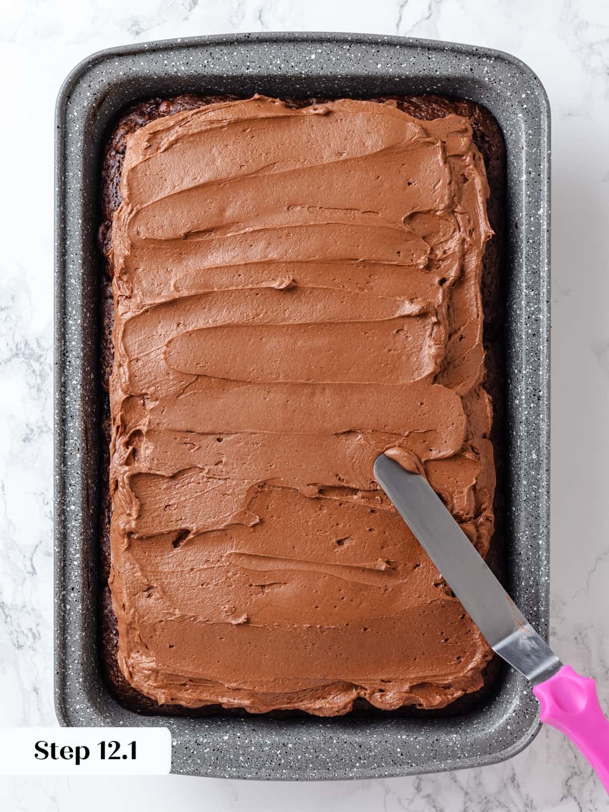 Frosting evenly layered over chocolate cake before decorative swirling.