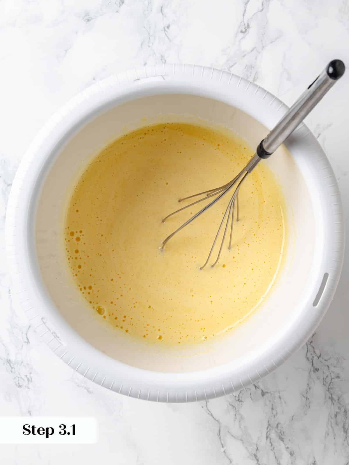 Eggs, vanilla extract, and sugar whisked together for chocolate cake batter.