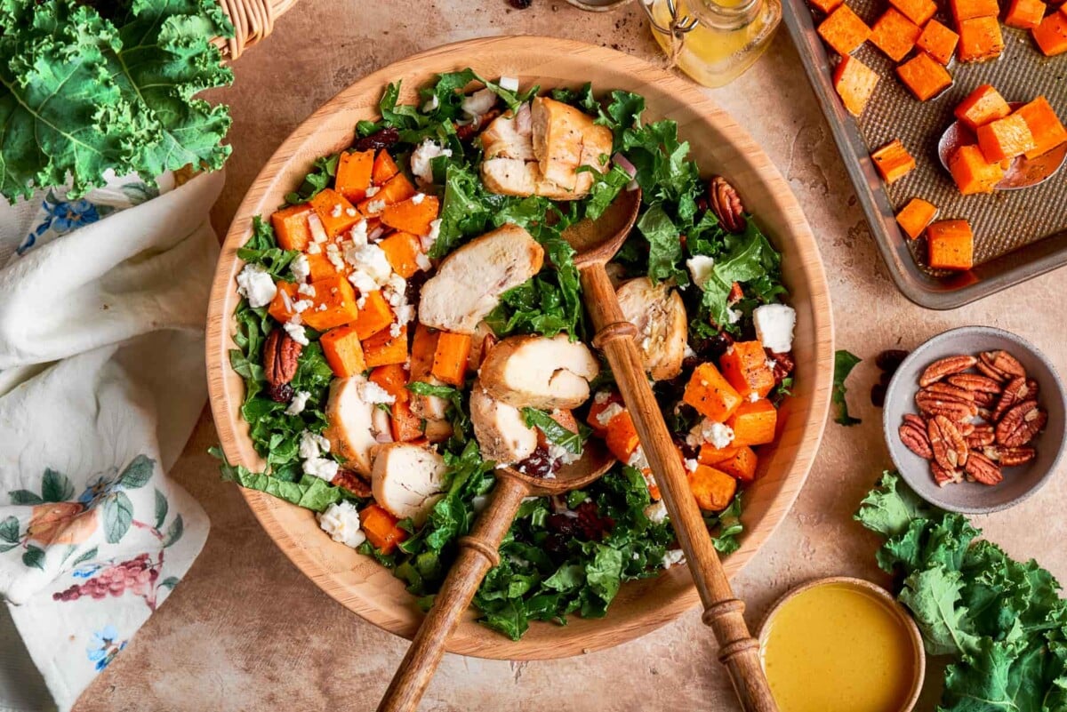 Large bowl of kale sweet potato salad set up for family style serving.