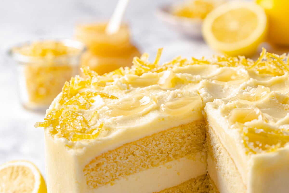 Decorated lemon cake sliced open to reveal buttercream layers inside.