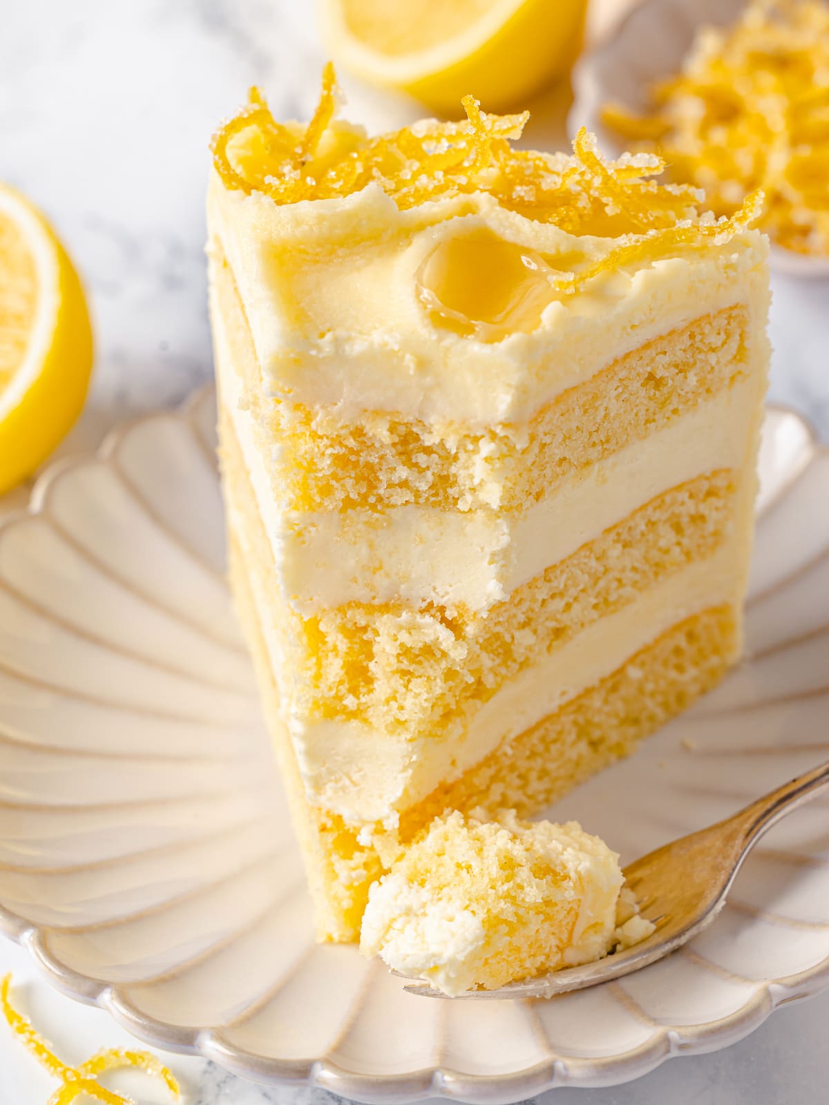 Bite of cake on fork showing soft crumb and silky lemon buttercream.