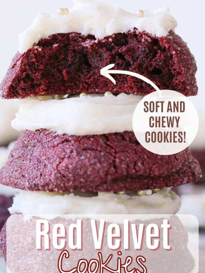 Red velvet cookies with vanilla buttercream frosting stacked and showing soft chewy centers.
