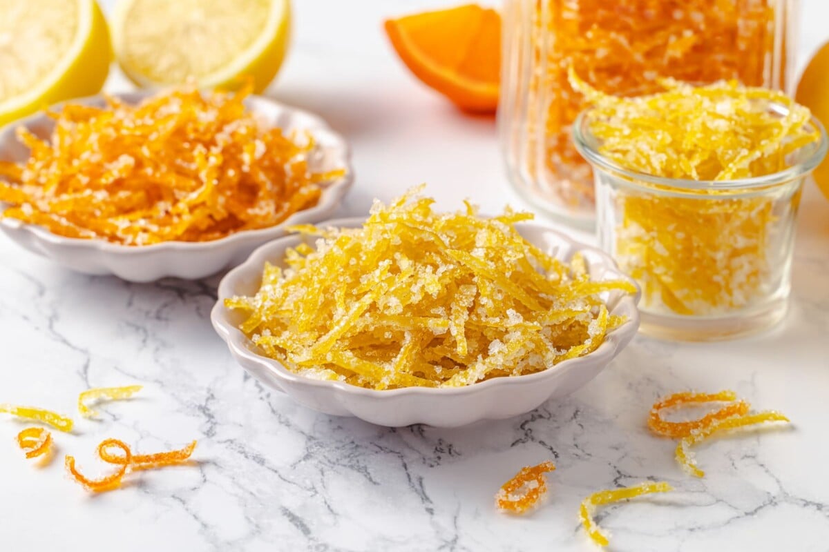 Glossy candied fruit peel resting on marble, emphasizing texture, color, and even candying.