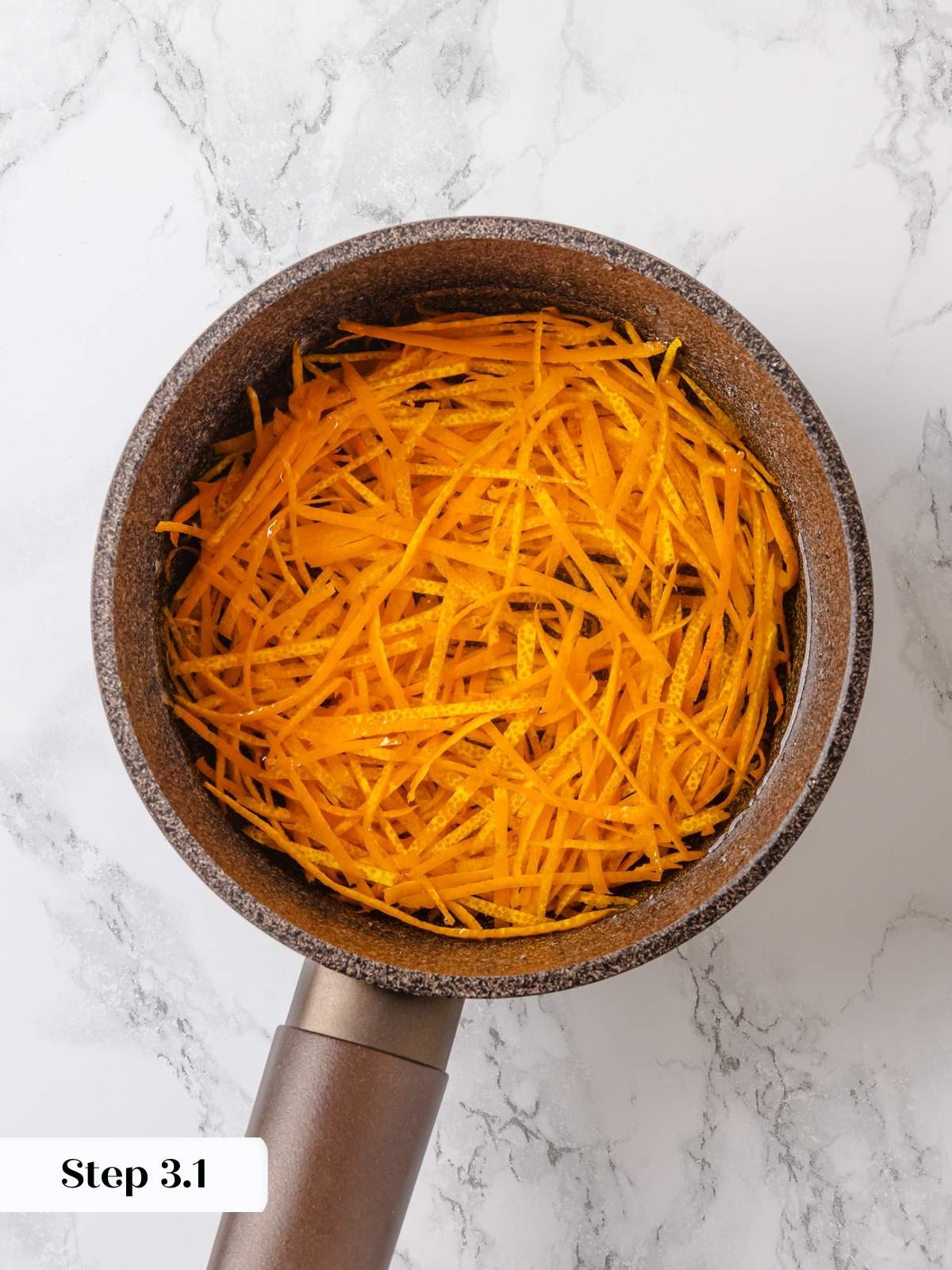 Orange peel boiling in water during blanching to remove bitterness before candying.