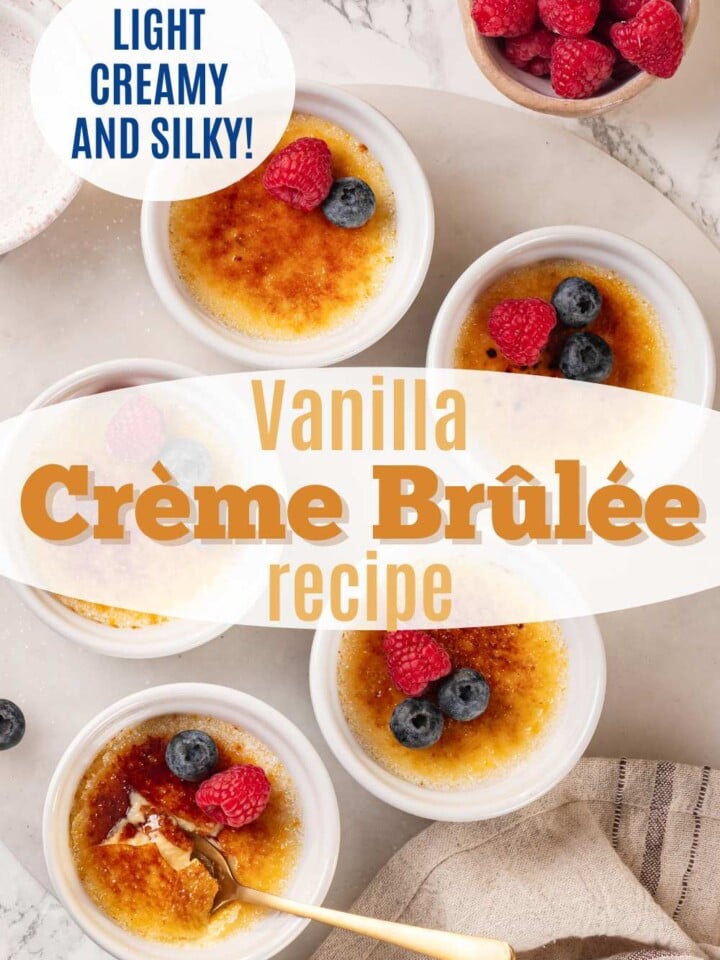 Ramekins of vanilla crème brûlée with a cracked caramelized sugar top, garnished with a raspberry and blueberries. Text overlay reads Recipe with only 7 ingredients.