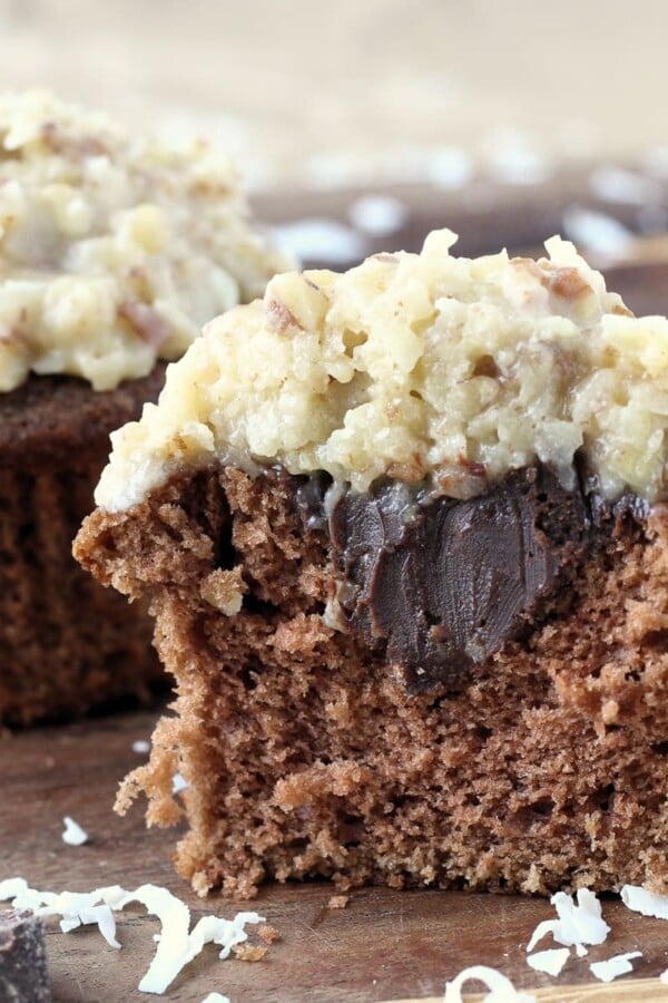 Split German chocolate cupcake showing soft, airy chocolate crumb inside.