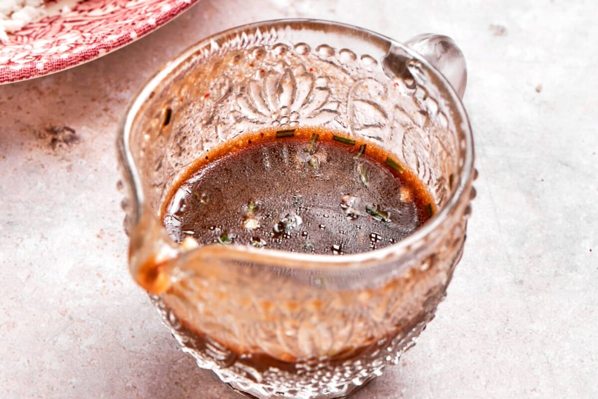 Lemon balsamic dressing presented in small glass gravy dish.