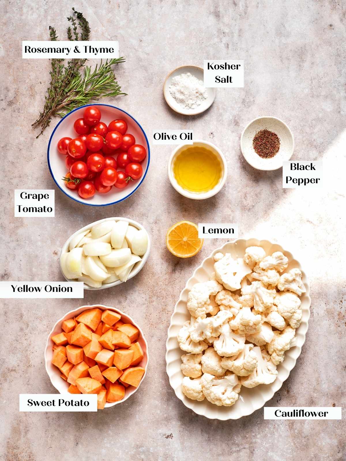 Cauliflower, sweet potatoes, onions, and tomatoes prepped for roasting.