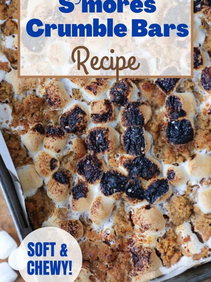 Stack of S'mores crumble bars with graham cracker crumble crust topped with melty toasted marshmallows. Text overlay reads with soft graham cracker crumble.