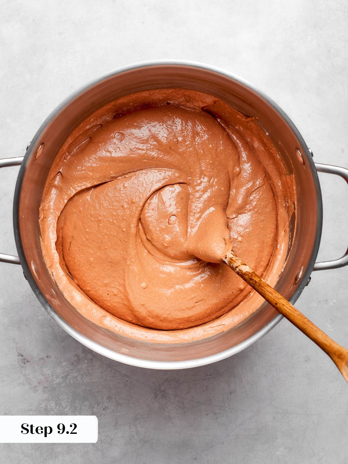 Thick chocolate batter with glossy texture prepared for baking cake layers.