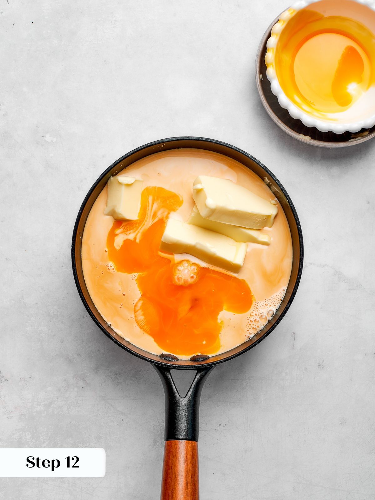 Custard base simmering with evaporated milk, butter, sugar, and egg yolks.