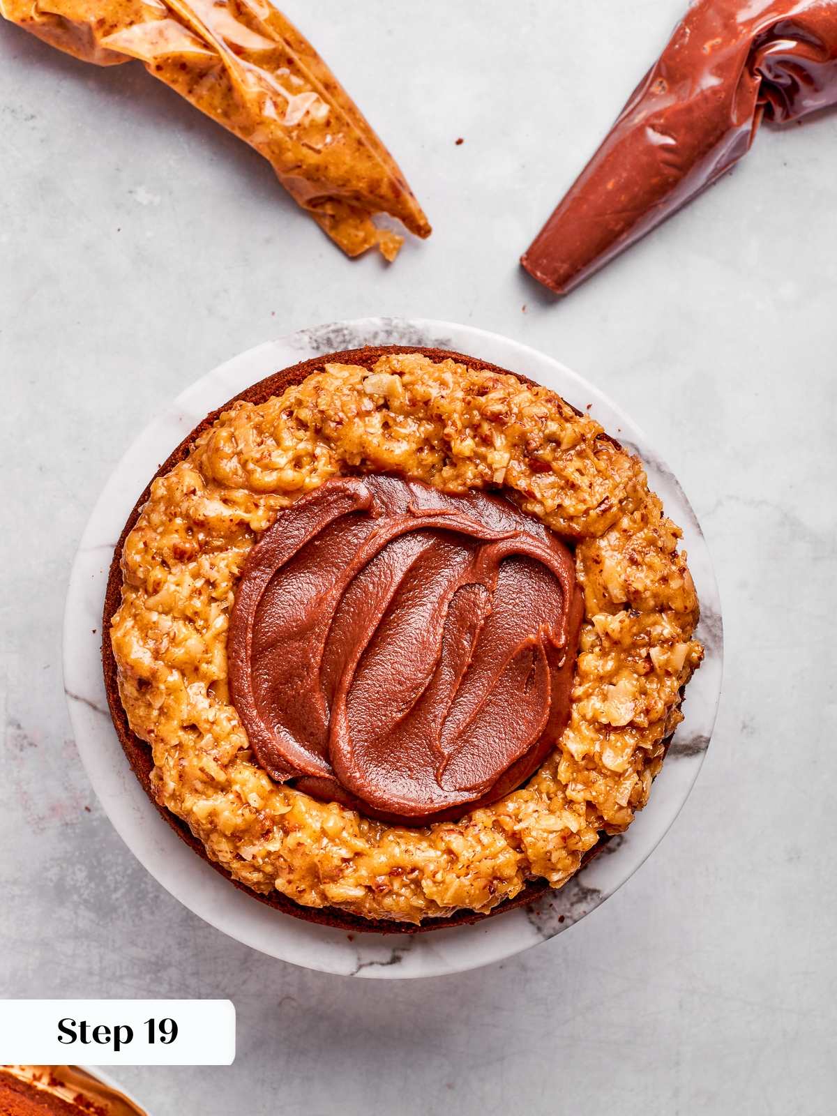 Chocolate ganache spread inside frosting dam between German chocolate cake layers.