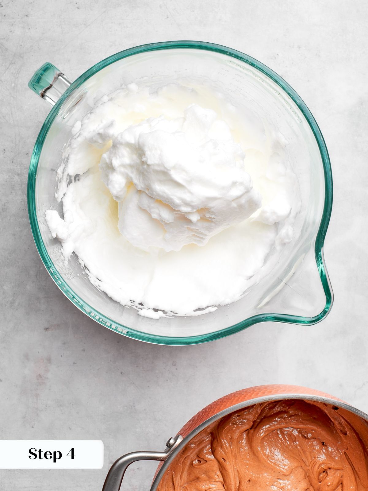 Egg whites whipped to stiff peaks in mixer bowl for cake batter.