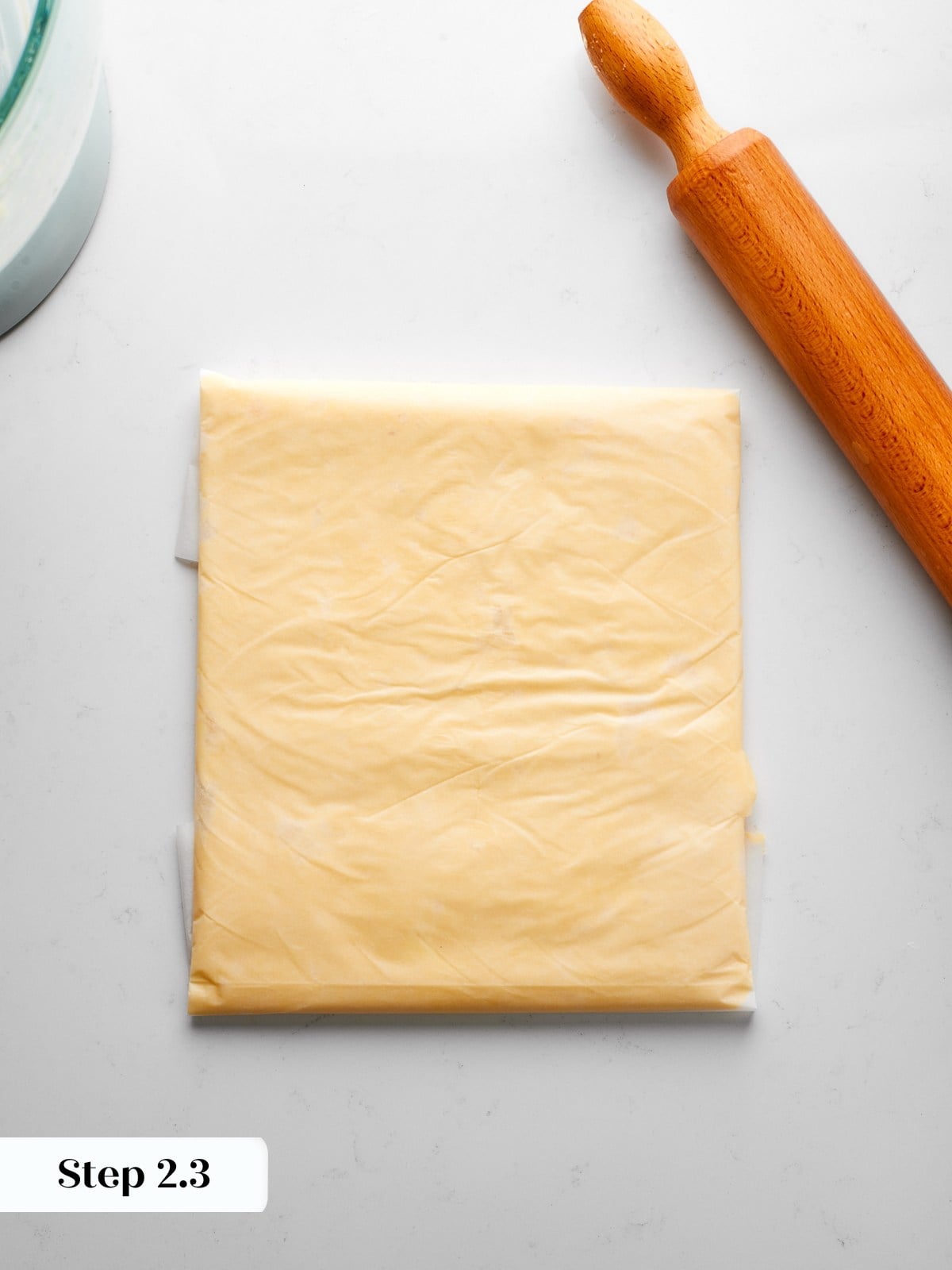 Butter mixture folded and pressed evenly inside parchment to form square block.