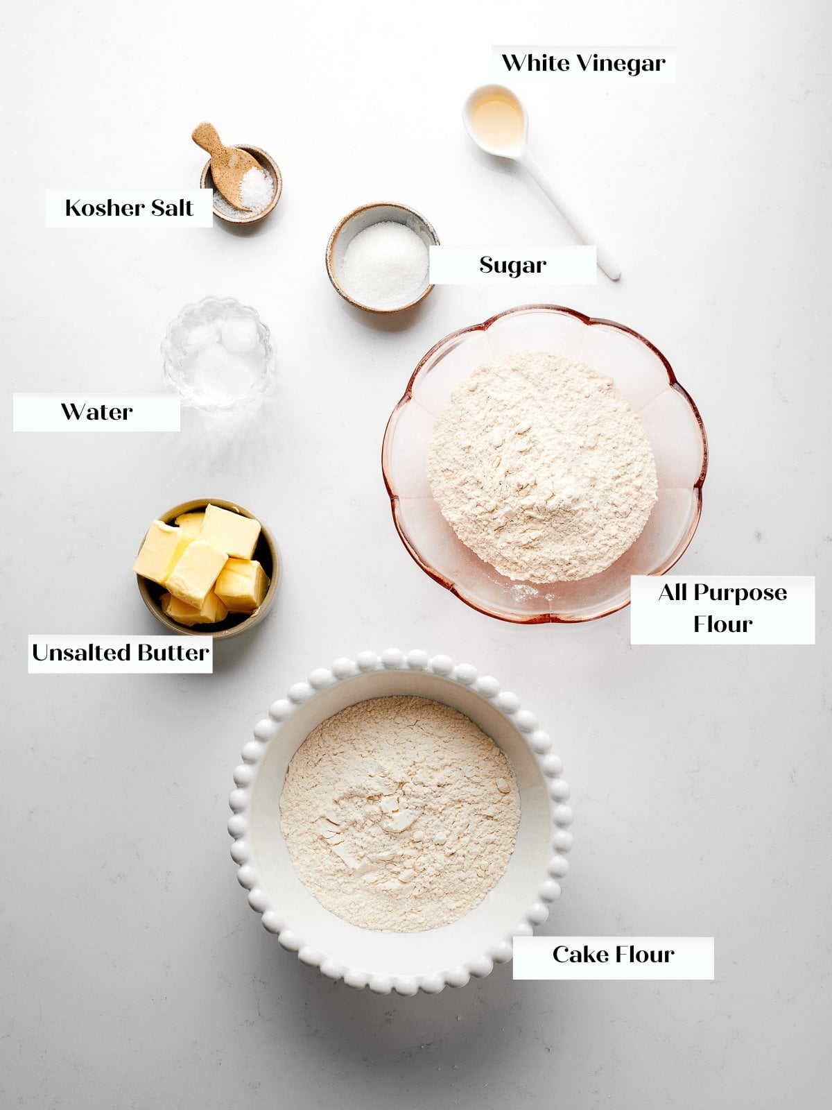 Ingredients for détrempe arranged on countertop including flour, butter, salt, sugar, and vinegar.