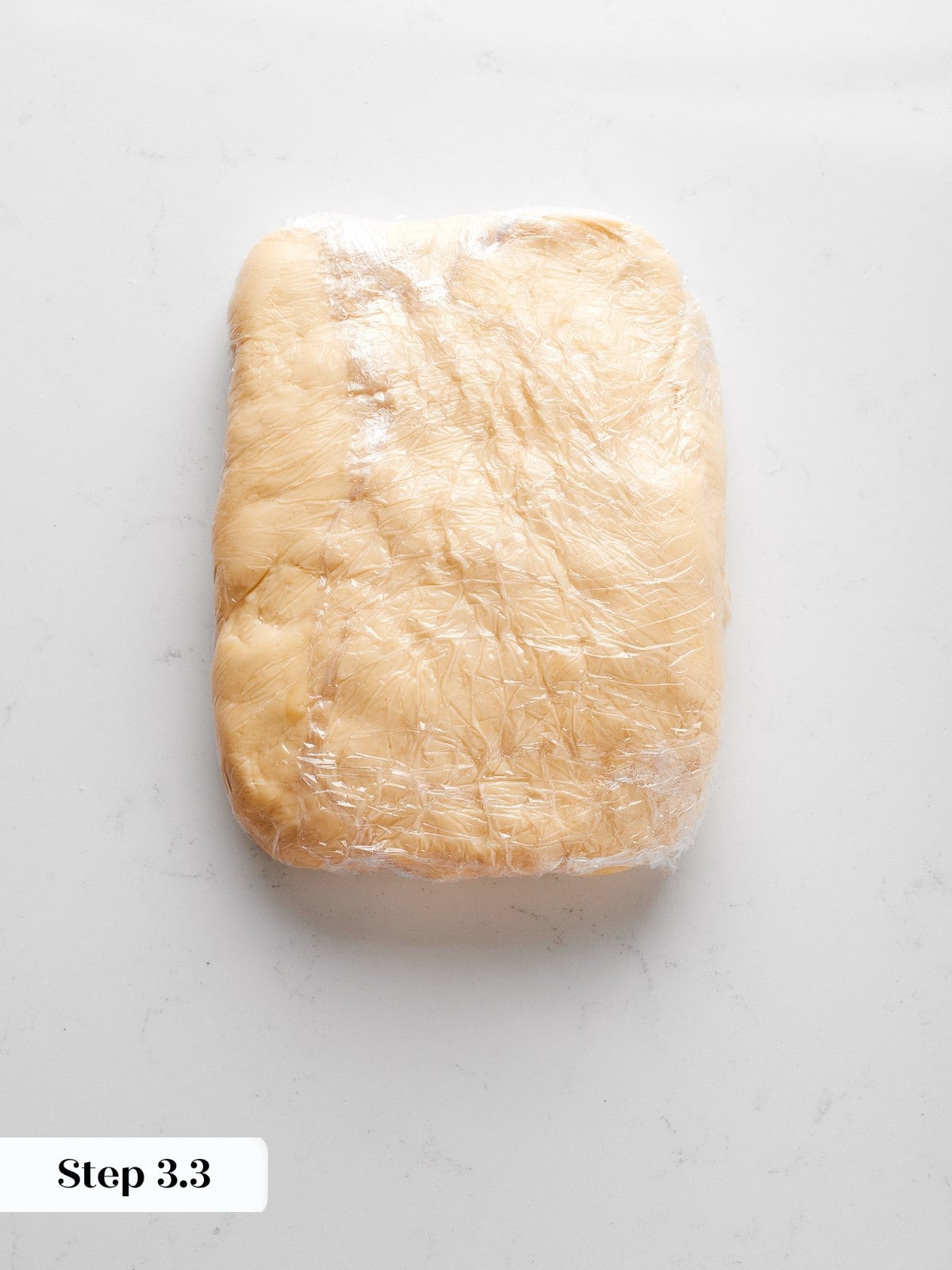 Firm dough square after chilling, structured and prepared for lamination with butter block.