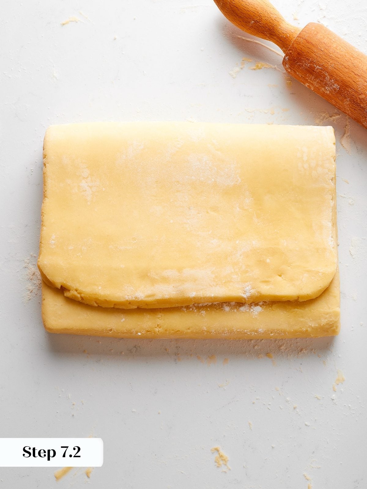 Dough folded into thirds during second envelope fold, layers aligned for even lamination.