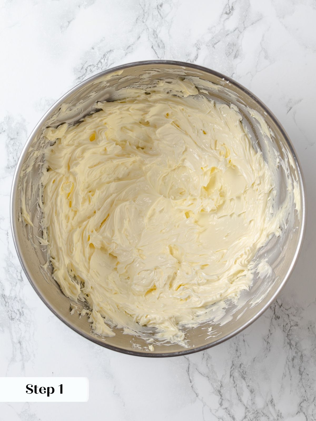 Softened butter beating in stand mixer bowl to create fluffy base for buttercream.