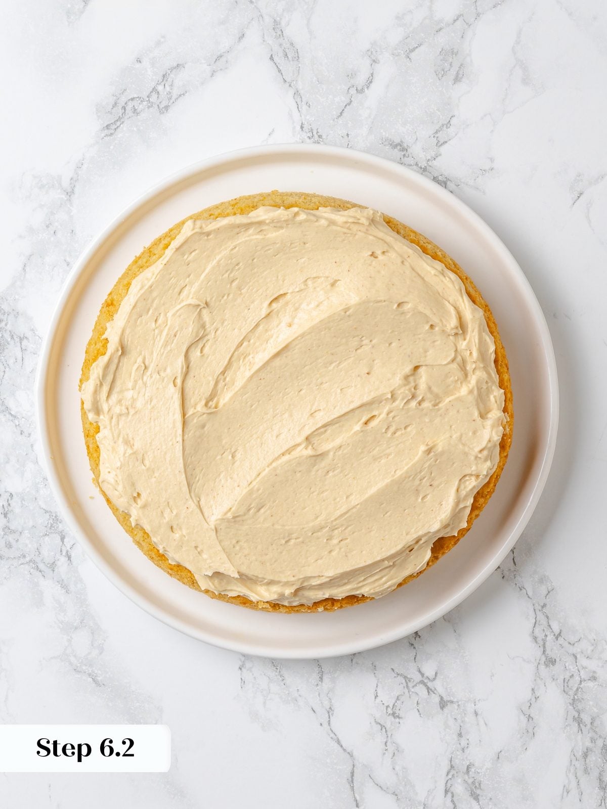 First layer of cake covered with peanut butter buttercream before stacking second layer.