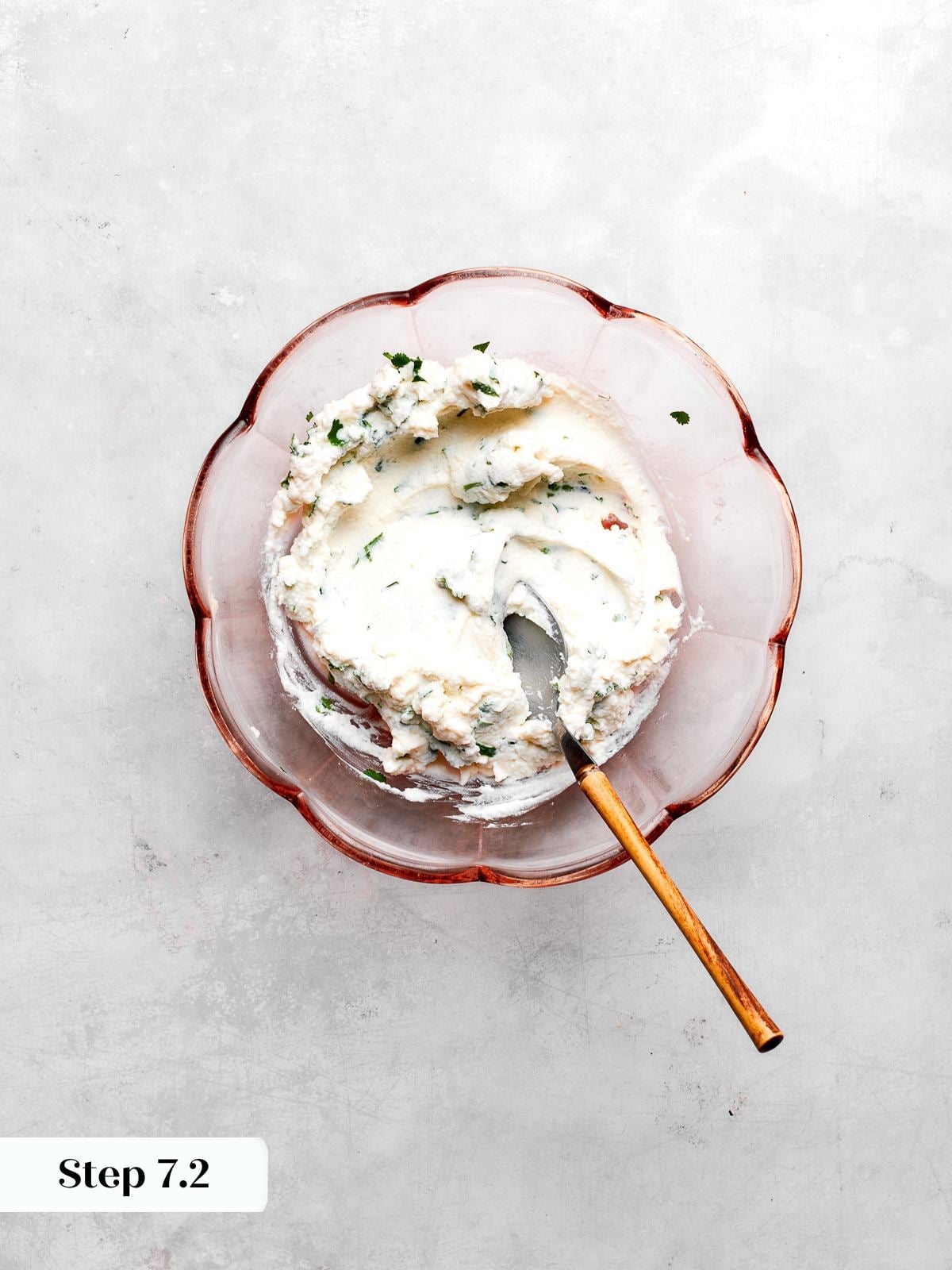 Ricotta filling mixed with chopped cilantro in bowl for spaghetti squash lasagna layers.