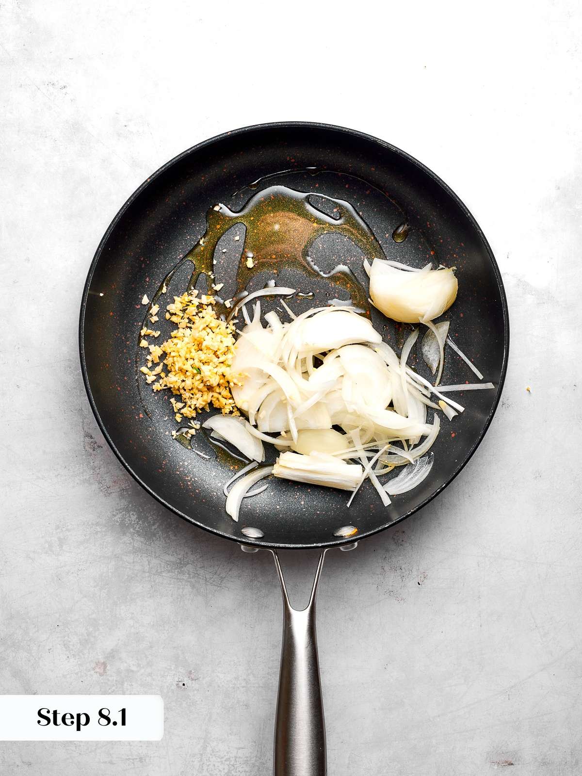Cooking sliced onions and minced garlic until fragrant and translucent in skillet.