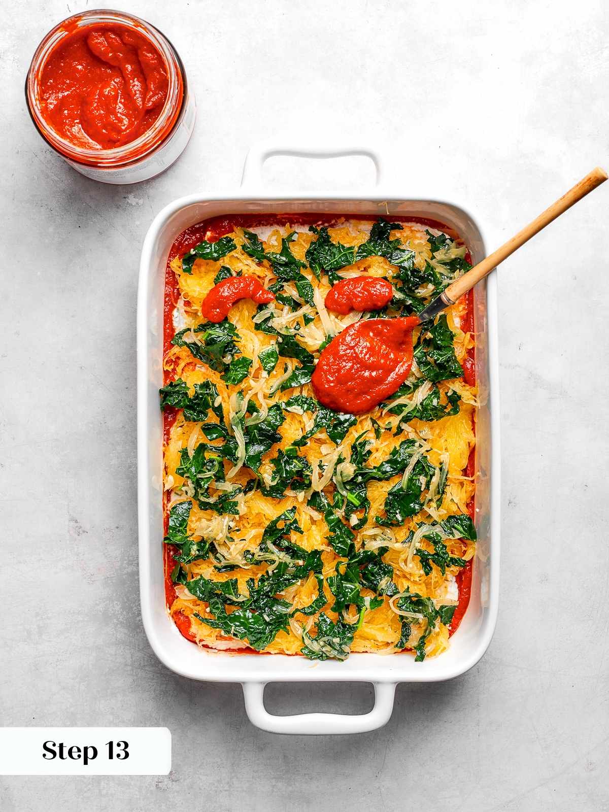 Vegetable mixture layered over squash with kale, onions, and garlic distributed evenly.