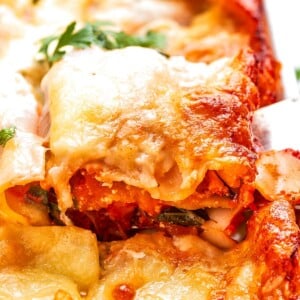 Square of lasagna lifted from pan holding shape with layered squash and cheese.