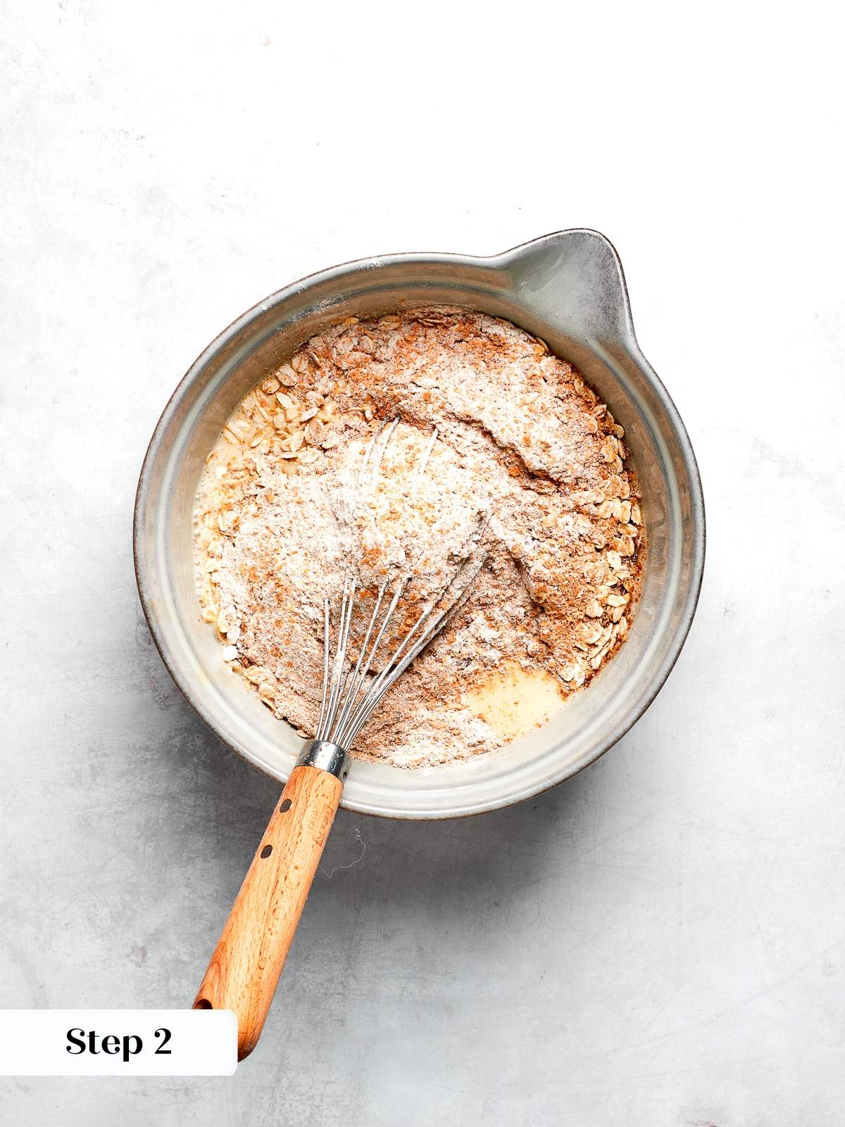 Dry ingredients whisked together including whole wheat flour oats flax and spices.