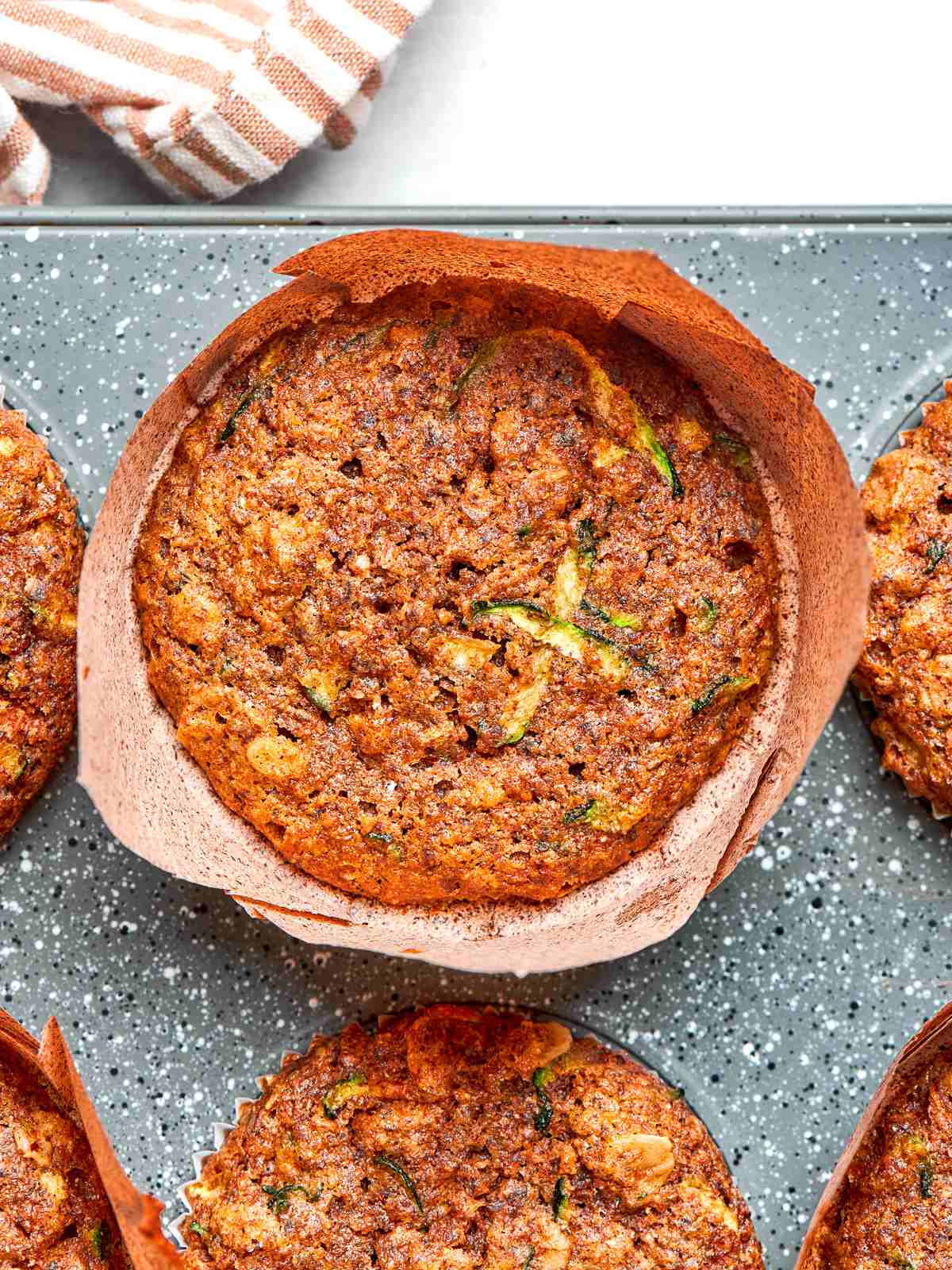 Fresh zucchini muffins with lightly set edges and golden tops.