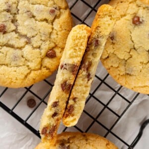 Chocolate chip cookie broken in half showing thick structure and soft, slightly gooey interior.