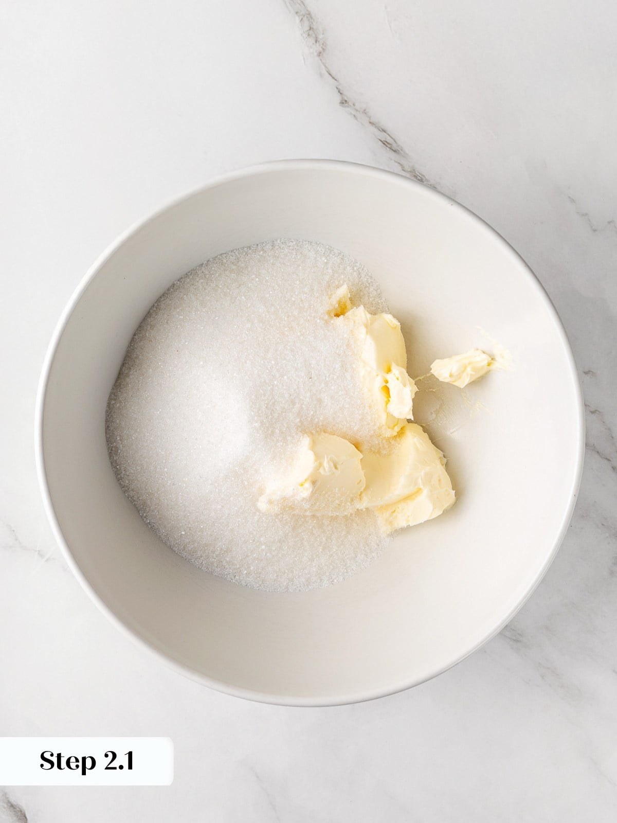 Butter and sugar combined in bowl before creaming for cookie dough base.