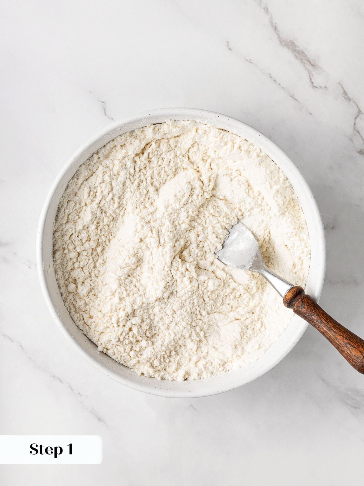 Dry ingredients being whisked together in bowl before adding to dough.
