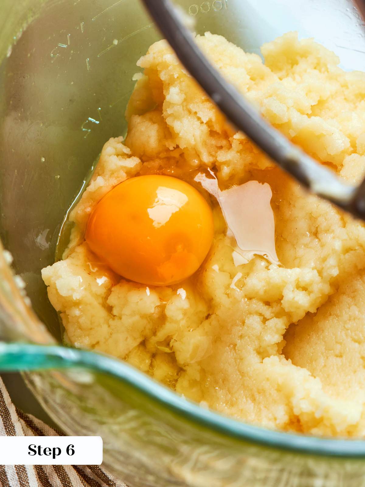 adding eggs to choux paste in mixer.